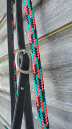 Load image into Gallery viewer, A close-up of a black leather hanger and pink, black, and turquoise loop reins.
